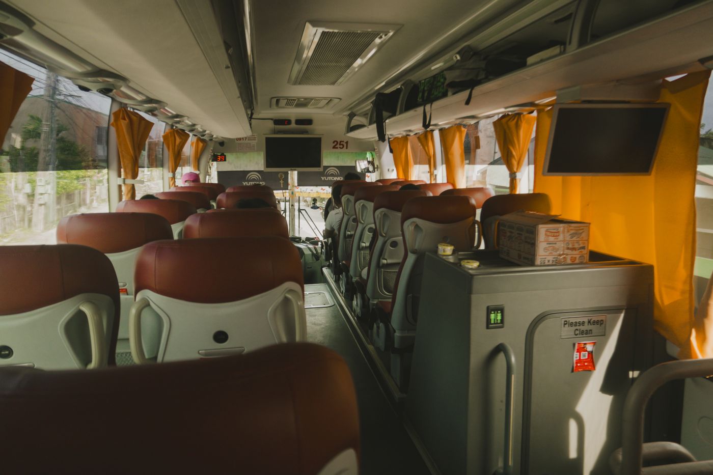 Premium motorcoach interior with leather reclining seats, overhead storage, and reading lights